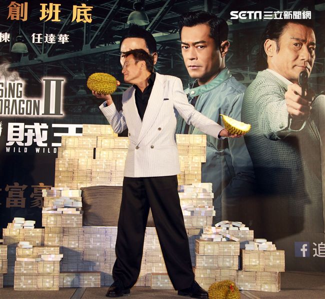 梁家輝因拍「追龍II賊王」的戲吃了三箱榴槤，電影公司特別在記者會現場讓梁家輝剝榴槤讓他想逃。（記者邱榮吉/攝影）