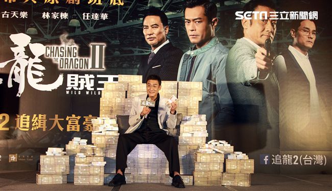 梁家輝出席電影「追龍II賊王」記者會，霸氣帥坐在鈔票椅瀟灑狂噴鈔票，展現史上最強悍匪氣魂。（記者邱榮吉/攝影）