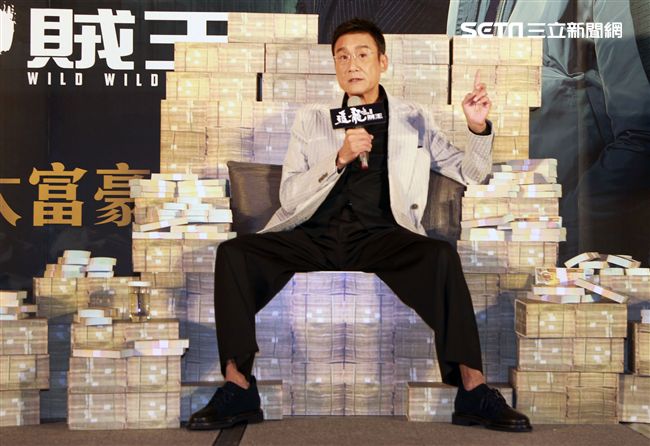 梁家輝出席電影「追龍II賊王」記者會，霸氣帥坐在鈔票椅瀟灑狂噴鈔票，展現史上最強悍匪氣魂。（記者邱榮吉/攝影）