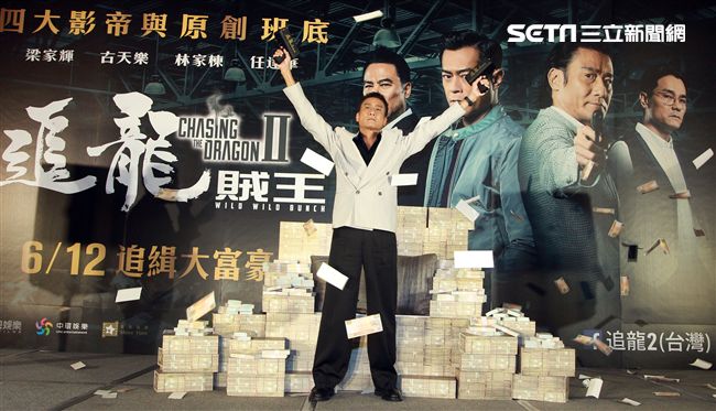 梁家輝出席電影「追龍II賊王」記者會，霸氣帥坐在鈔票椅瀟灑狂噴鈔票，展現史上最強悍匪氣魂。（記者邱榮吉/攝影）