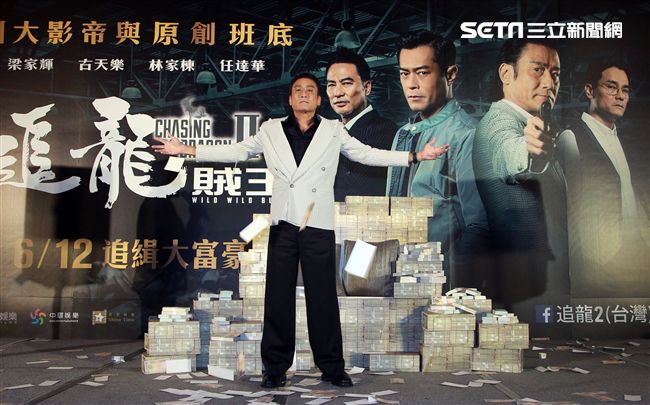 梁家輝出席電影「追龍II賊王」記者會，霸氣帥坐在鈔票椅瀟灑狂噴鈔票，展現史上最強悍匪氣魂。（記者邱榮吉/攝影）