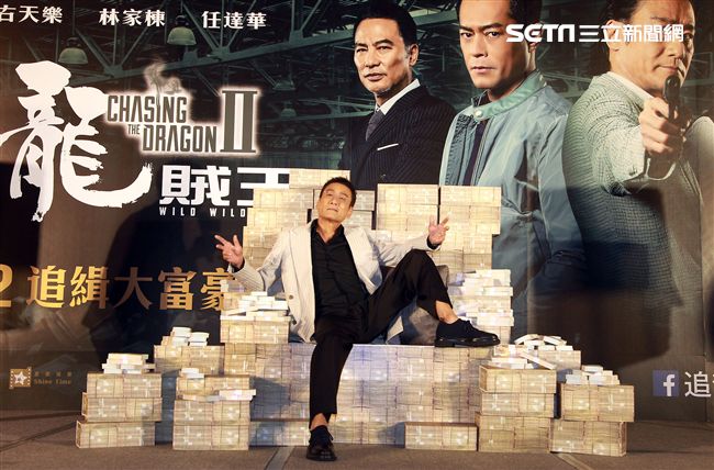 梁家輝出席電影「追龍II賊王」記者會，霸氣帥坐在鈔票椅瀟灑狂噴鈔票，展現史上最強悍匪氣魂。（記者邱榮吉/攝影）