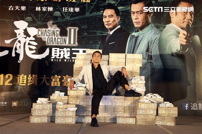 梁家輝出席電影「追龍II賊王」記者會，霸氣帥坐在鈔票椅瀟灑狂噴鈔票，展現史上最強悍匪氣魂。（記者邱榮吉/攝影）