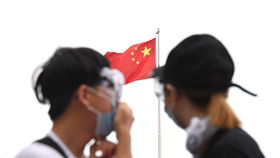 香港反送中　抗議民眾抬頭望見五星旗香港警方12日下午施放催淚瓦斯試圖驅離立法會外反送中的抗議民眾，部分民眾頭戴護目鏡、口罩持續抗爭，有民眾抬頭望著一旁的五星旗。中央社記者王飛華攝　108年6月12日