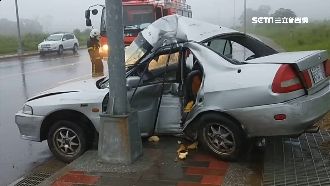 疑下坡過彎打滑　轎車失控撞電線桿