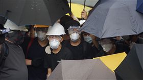 反送中示威者阻七一升旗典禮（3）香港主權移交22週年，官方預定1日早上8時舉行升旗典禮，一群反對港府修訂逃犯條例的示威者試圖阻止升旗儀式進行，示威者穿戴防護裝備，以雨傘阻擋警方噴灑辣椒水。中央社記者裴禛香港攝　108年7月1日