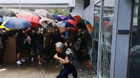 反送中的抗爭持續進行，有一群示威者直接拿鐵馬等工具衝立法會的玻璃門，企圖撞破立法會玻璃門，警方則舉起紅旗警告並噴辣椒水，但示威者不放棄，拿著雨傘、戴著防毒面具與口罩與警方對峙。（圖／翻攝自推特）