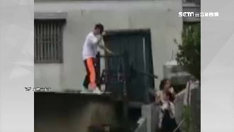 颱風天玩命！遊客為拍照爬上住家屋頂