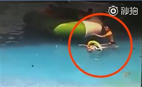 日前在大陸四川一處水上樂園的游泳池內，一名11歲女童不幸溺斃，相關人員調閱監視器後發現，女童疑似是被一個大型的充氣船壓在船底，當她的身體隨著救生圈浮上水面時，已經不幸斷氣。當時一名成年男子推著充氣船經過，看到女童漂在水面，但他居然沒立即上前查看，還若無其事的推著船走掉，導致女童錯過黃金救援時間，冷血的行徑令人髮指。（圖／翻攝自紅星新聞）