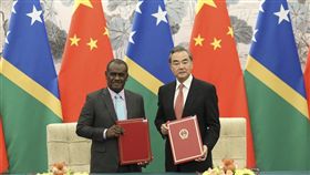 索羅門群島外交部長馬內列（左）21日與中國國務委員兼外交部長王毅（右）在北京簽署建交公報。（中新社提供）
