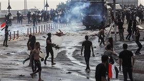 伊拉克反政府示威延燒，鎮暴警察以強力水柱和催淚瓦斯清場，甚至以實彈驅趕示威群眾。據半島電視台報導，包括4名警察在內，這一波抗議潮已經造成44人喪生。圖為1日於巴格達解放廣場的示威現場。（檔案照片／法新社提供）