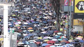 禁蒙面法首日　港人仍戴口罩遊行5日是香港實施禁蒙面法的第一天，但是許多港人仍然戴著口罩遊行抗議。圖為遊行隊伍下午3時許抵達灣仔，龍頭手持「我願榮光歸香港」的布條。中央社記者張謙香港攝　108年10月5日