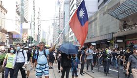 香港反送中示威仍持續進行，蘋果公司港版iPhone鍵盤隱藏中華民國國國旗表情符號。圖為1日反送中遊行，有人舉起中華民國國旗。（中央社檔案照片）