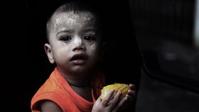 天真無邪難民幼童似未感受成人生活壓力流落到馬來西亞難民外出拚經濟之際，兒童多半在住家附近巷弄玩耍，圖為稚齡幼童於傍晚昏暗光線下啃著熱呼呼玉米，天真無邪表情中似未感受成人生活壓力。中央社記者黃自強吉隆坡攝　108年10月18日