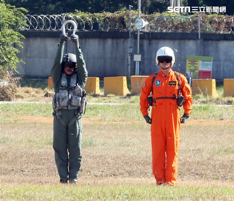 UH-1H直升機代表（右）將象徵執行吊掛任務的「U形環」，正式交接給UH-60M黑鷹直升機代表（左），代表新、舊機種的任務正式接替以及薪火傳承的精神，未來將由黑鷹直升機肩負各項任務與使命。（記者邱榮吉/台中拍攝）