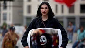 學者指出，示威者扮小丑的其中一個原因是要向當權者釋出來自社會底層的警告。圖為妝扮為小丑的黎巴嫩示威者拿著自己的照片走上街頭。（法新社提供）