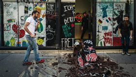 為慶祝柏林圍牆倒塌30週年，法國巧克力雕刻師羅傑（左）9日拿槌子敲毀他用巧克力做成的柏林圍牆復刻版，並把「圍牆」碎片分給路人，讓大家一起品嘗自由。（法新社提供）