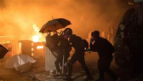 香港中文大學「反送中」學生12日在校園周邊與警方對峙，警方向學生發射催淚彈，學生向警方丟汽油彈。（法新社提供）