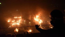 數十名防暴警察凌晨約5時30分從暢運道搶占理工大學大門處，校內示威者向警察丟擲多枚汽油彈並引燃路障，還有人從A座樓層平台丟擲汽油彈，現場一片火海。（共同社提供）