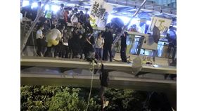 香港理工大學示威者持續被困，上百人18日晚間改用吊繩，試圖跳下馬路逃出校園，似有少數人被前往聲援的電動機車接走。（美聯社）