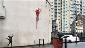 英國知名塗鴉藝術家班克西（Banksy）據信送給家鄉布里斯托一份情人節禮物，那就是出現在牆上的新作品，畫中可見一名小女孩手持彈弓射出一簇紅花煙火，居民發現後都相當驚喜。(圖/取自班克西IG網頁instagram.com/banksy)