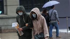 寒流到氣溫驟降寒流報到，中央氣象局16日上午發布最新低溫特報，受影響範圍擴大，從原本10縣市增加至17縣市，可能出現攝氏10度左右或以下氣溫。下午台北市區開始降雨，出遊民眾戴起帽子遮雨。中央社記者裴禛攝　109年2月16日