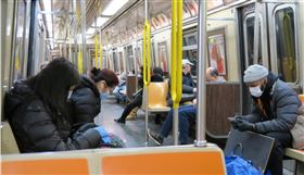 武漢肺炎重創全球經濟活動，央行坦言，由於疫情擴散地區及期間均遠大於SARS時期，目前境內外旅行活動似乎難有V型反彈。圖為紐約地鐵上愈來愈多非亞洲面孔戴起口罩。中央社記者尹俊傑紐約攝　109年3月19日