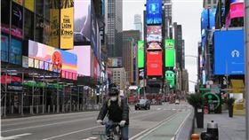 全球武漢肺炎官方確診人數至2日已超過90萬例，超過4萬5000人感染死亡。圖為美國紐約時報廣場一片冷清，單車騎士也戴起口罩。