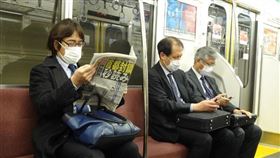 武漢肺炎疫情擴散，東京民眾憂封城，搭乘地鐵民眾閱讀頭版為「封城進入秒讀」的報紙。中央社記者楊明珠東京攝 109年3月26日