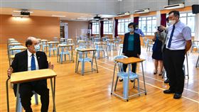 香港在疫情肆虐下舉行高中考試香港24日起在疫情肆虐下舉行中學文憑試（相當於高中考試），當局採取了嚴格的防疫措施，包括考場椅桌距離1.8公尺。圖為政務司司長張建宗（左）日前視察考場。（港府新聞處提供）中央社記者張謙香港傳真  109年4月24日
