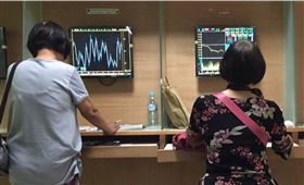 由於美股財報變數及上檔反壓，加上台灣防疫有成，法人預期台股將於區間高檔震盪。圖為民眾看台股。（中央社檔案照片）