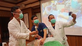 花蓮慈濟研發氣管內管呼吸系統（3）花蓮慈濟醫院麻醉部團隊改良現有防護罩、插管器材，研發出「氣管內管呼吸系統」，麻醉部副主任陸翔寧（右）、術後急性疼痛科主任楊曜臨（左）及醫師黃景旋（中）示範操作方式。中央社記者張祈攝  109年5月7日