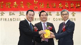 金管會主委交接　黃天牧正式上任金融監督管理委員會20日下午舉行新、卸任主委交接典禮，在行政院政務委員羅秉成（中）監交下，卸任主委顧立雄（左）將印信交給新任主委黃天牧（右）。中央社記者王騰毅攝　109年5月20日