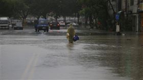 高雄市滂沱大雨（3）受滯留鋒面及西南氣流影響，高雄市區22日下起滂沱大雨，鹽埕區七賢抽水站有一台抽水機故障，造成大公路、富野路一帶無法排水，民眾拿著水桶在雨中前行。中央社記者董俊志攝  109年5月22日