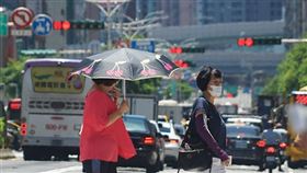 中央氣象局持續發布高溫資訊。北市交工處從6月中到9月，縮短全市主要道路紅燈秒數，減少用路人曝曬時間。圖為台北市區天氣炎熱，民眾出門撐傘遮陽。中央社記者裴禛攝　109年6月16日