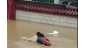 一段名為「爸爸游泳背女兒高考」的影片在網路上瘋傳。（圖／翻攝自搜狐）