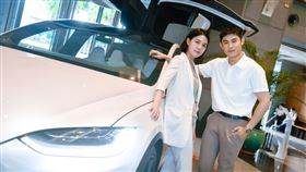 扮演小資族的美女副發言人戴湘儀、替代役男星陳奕，甜蜜在特斯拉前擺拍。（圖／新北市政府新聞局提供）