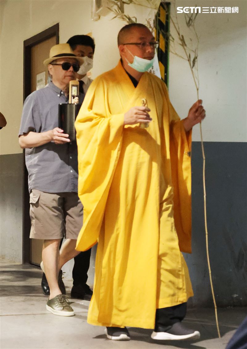 羅大哥手捧羅霈穎的牌位，搭車前往民權東路靈堂現場。（記者邱榮吉/攝影）