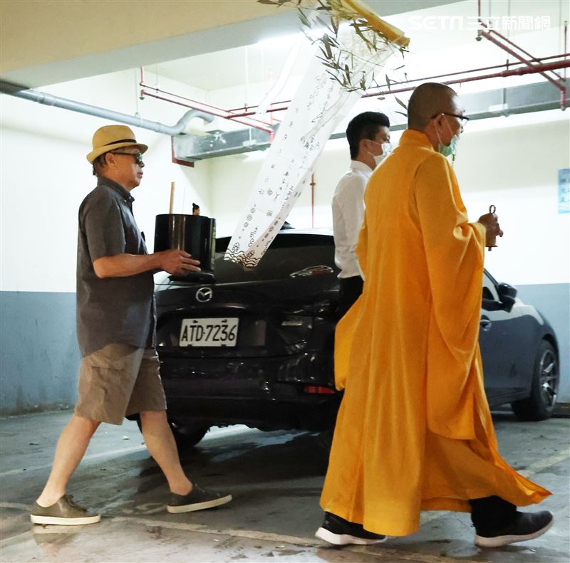 羅大哥手捧羅霈穎的牌位，搭車前往民權東路靈堂現場。（記者邱榮吉/攝影）