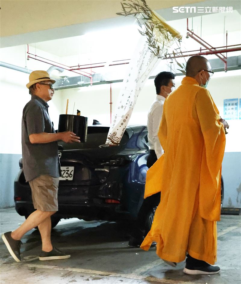 羅大哥手捧羅霈穎的牌位，搭車前往民權東路靈堂現場。（記者邱榮吉/攝影）