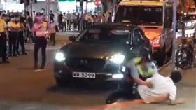 香港泛民派立法會議員許智峯（穿白衣）14日晚間攔下一輛跟蹤他的車輛後報警，但警方調查後放行該車，引發許智峯不滿欲上前攔阻該車離去，反遭警察推倒。（圖／翻攝自許智峯臉書）