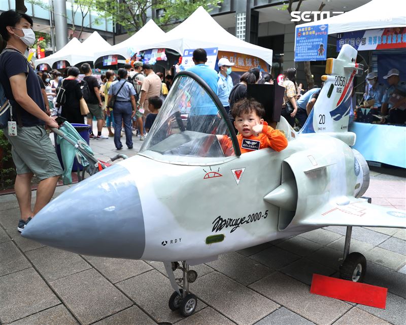 國防部舉辦的「九三香堤嘉年華─超級愛國軍Yes Sir」活動，小朋友穿著飛行服帥氣的坐上迷你戰機。（記者邱榮吉/攝影）