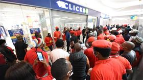 南非知名藥粧連鎖超市克里克斯，上週在網頁刊出一則歧視黑人女性頭髮的美髮品廣告，引發眾怒。第三大政黨經濟自由鬥士於7日號召黨員到克里克斯各地分店示威。（圖／翻攝自facebook.com/economicfreedomstruggle）
