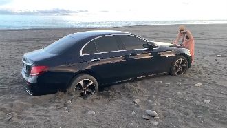 夫妻海邊浪漫賞景　百萬豪車卡沙灘