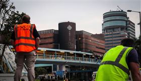 針對在「反送中」示威衝突中有人冒充記者在前線採訪，香港警方決定修訂媒體代表定義。圖為2019年11月19日警方包圍香港理工大學，並在校區外設防線，大批媒體校外守候消息。（中央社檔案照片）