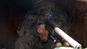 狙擊手躲在偽裝神出鬼沒深溝裡準備出擊。（記者邱榮吉／台中拍攝）