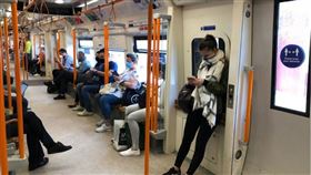 英國政府首席科學顧問瓦朗斯表示，儘管英國已展開大規模的武漢肺炎疫苗施打計畫，民眾可能還得戴口罩一年。圖為倫敦民眾搭地鐵戴口罩防疫。（中央社檔案照片）