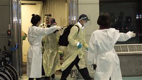 英國班機抵台　旅客下機檢疫人員引導（1）華航一架從英國載送114名旅客的班機27日下午約5時36分抵達桃園國際機場，旅客走獨立通道，機場人員嚴陣以待，有症狀者先在機場個別採檢，發燒者送醫，其他人則分別送往3處集中檢疫所採檢，檢疫期滿前也會再次採檢。中央社記者吳睿騏桃園機場攝  109年12月27日