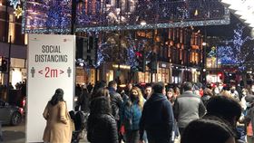 倫敦街頭購物人潮12月倫敦街頭如同往年掛起耶誕燈飾，但路邊警告保持2公尺社交距離的告示，以及戴著口罩的民眾，讓人體會到生活已因疫情改變。中央社記者戴雅真倫敦攝  109年12月28日