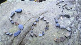 台中50歲陳姓男子，上個月26日單攻白姑大山失蹤已7日，搜救隊在登仙溪溪岸，發現多處用石頭排出的「SOS」，不排除是陳姓男子發出的求救訊號。(圖／南投縣消防局提供)